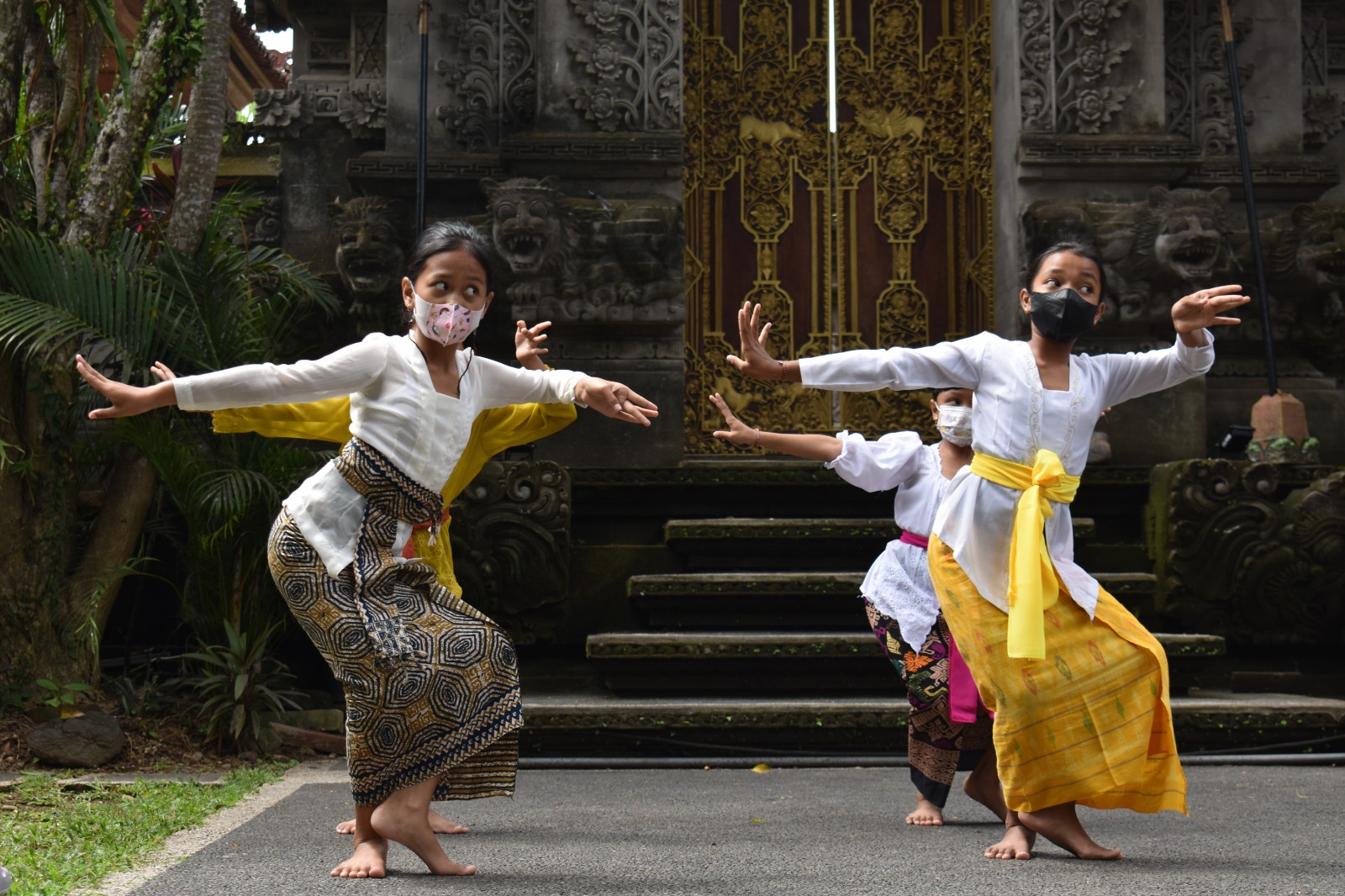 Children performing a traditional dance in front of a temple gate