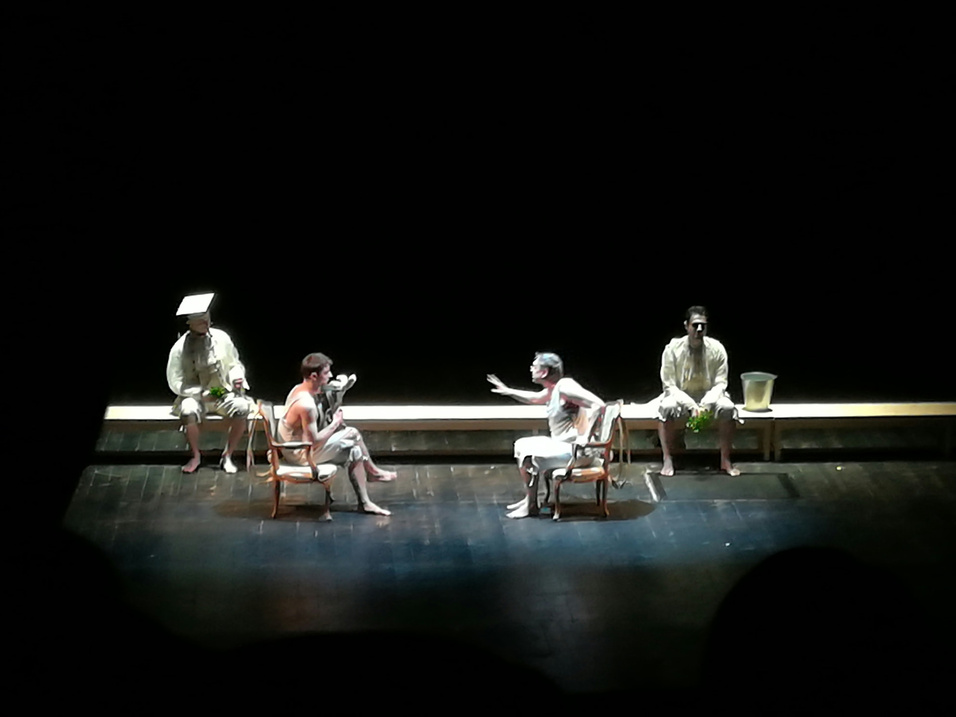 Actors on a bare stage in a community theatre performance