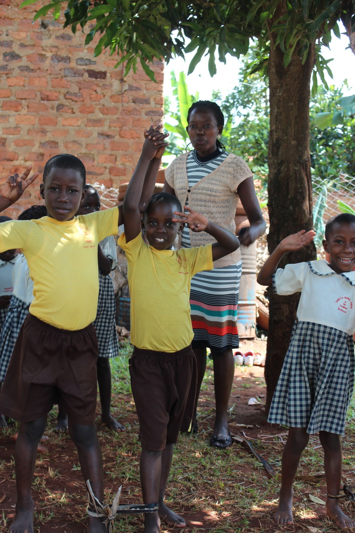 A schoolyard gathering, hands raised in greeting