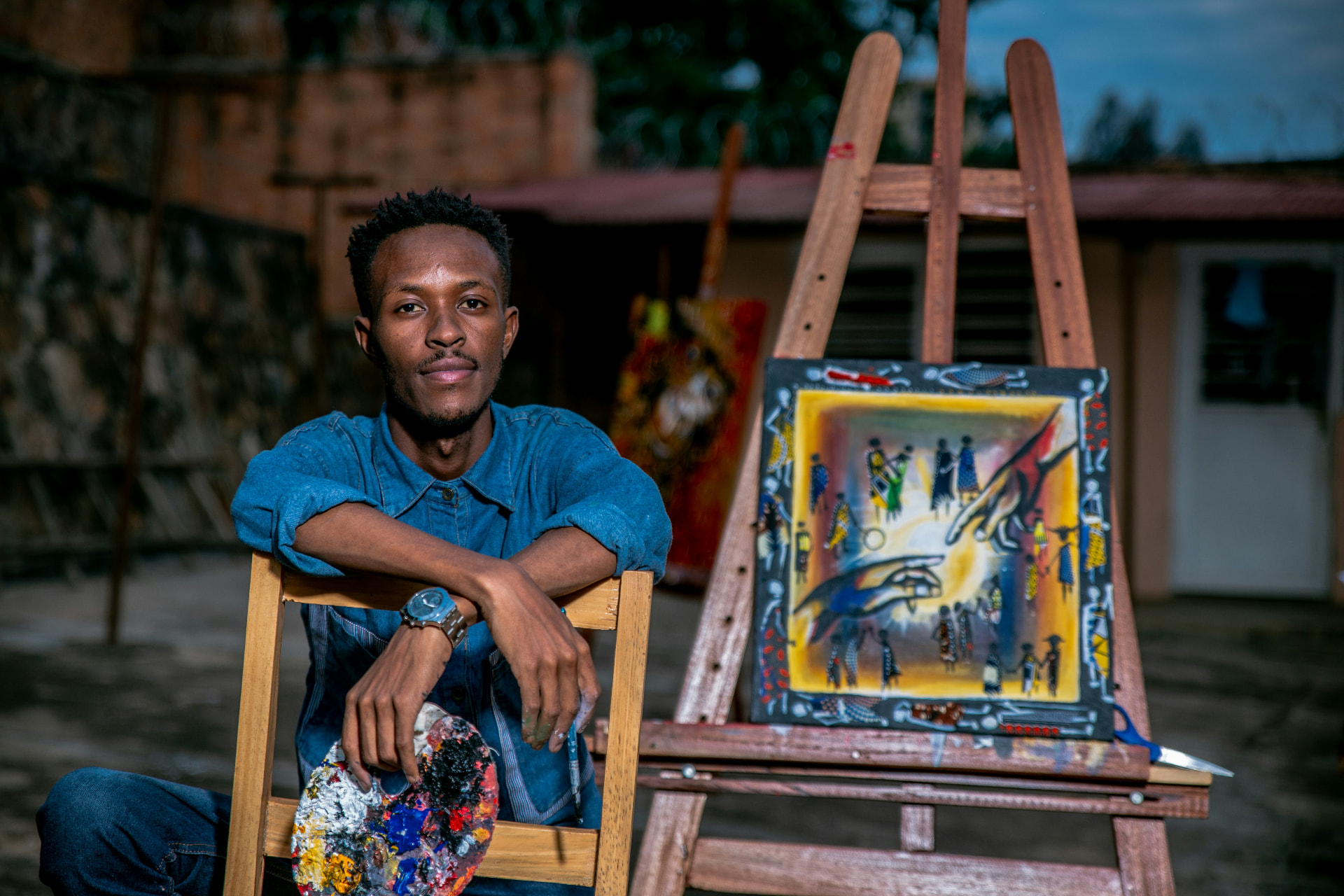 A young painter beside his work in an outdoor studio