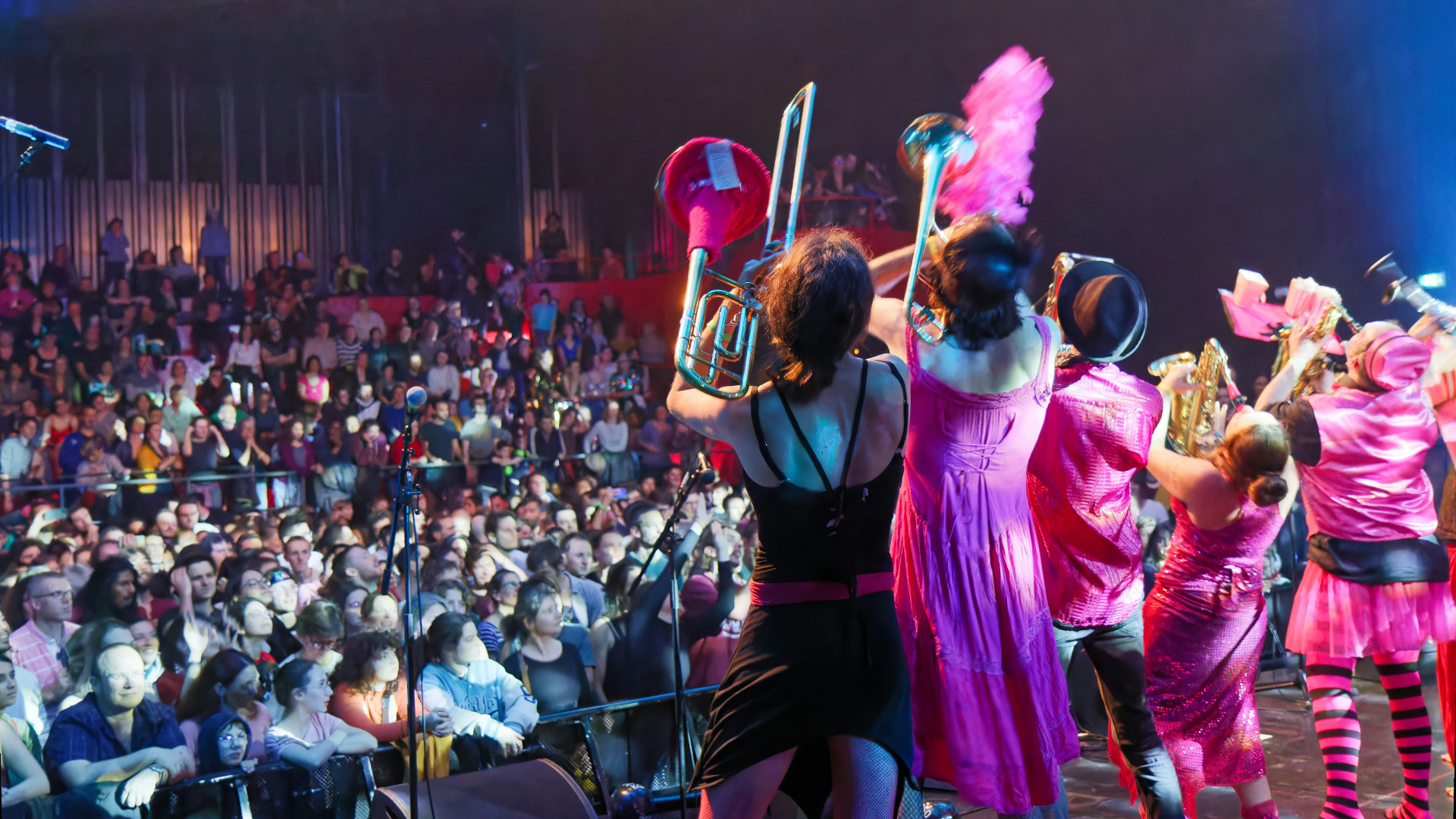 A brass band performing for a packed audience
