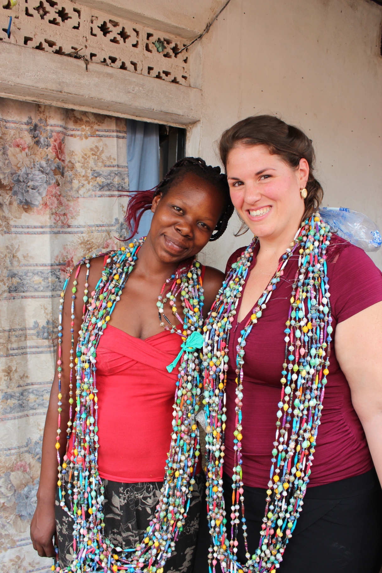 Two artists wearing beads made by their community