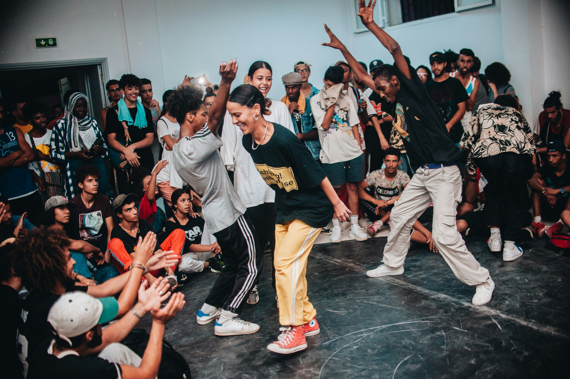 Young dancers in a street dance circle surrounded by their community