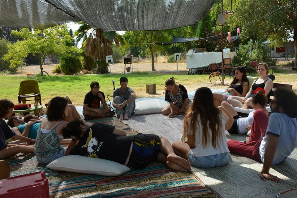 A circle of friends gathered under a shaded canopy