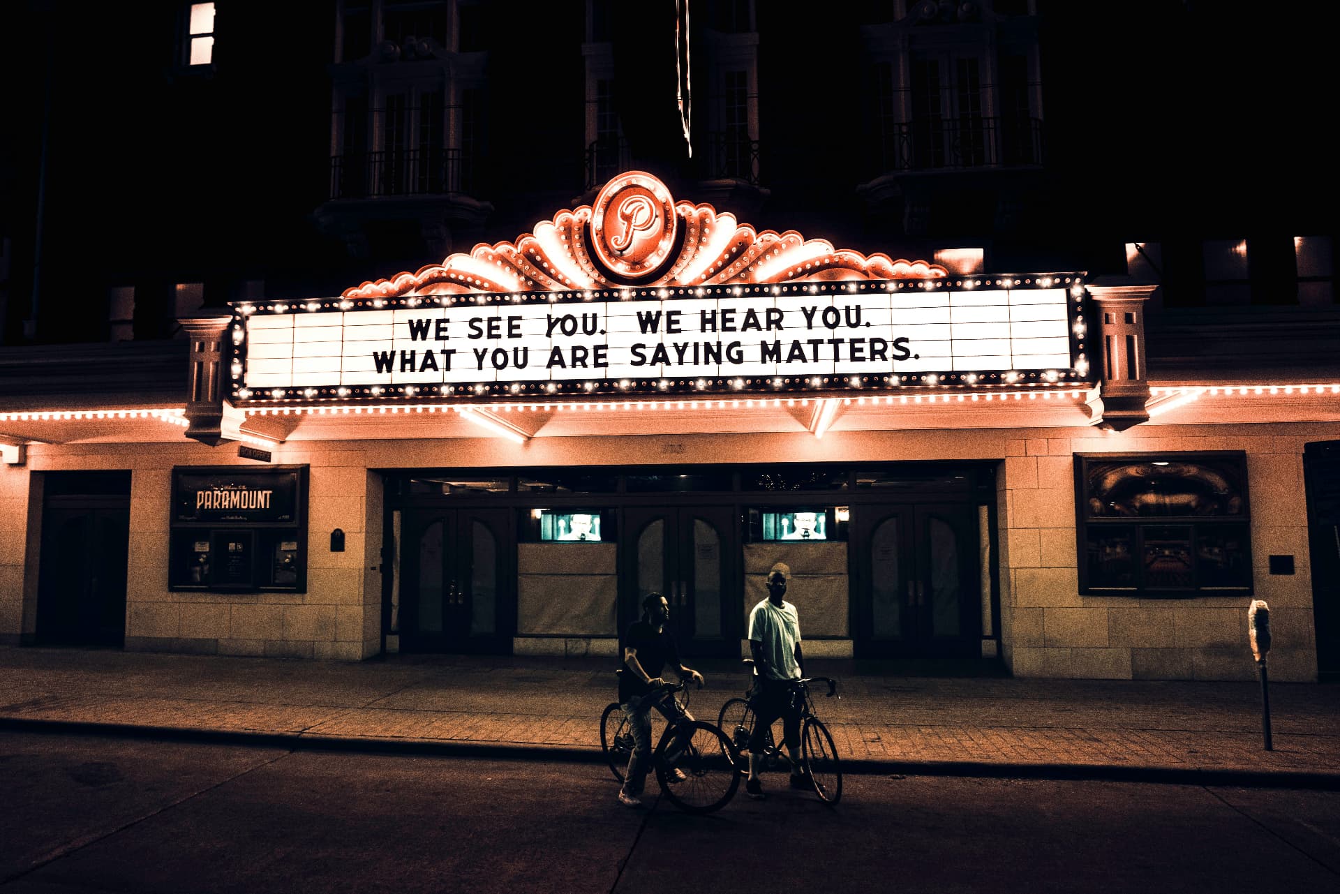 A theatre marquee reading 'We see you. We hear you. What you are saying matters.'
